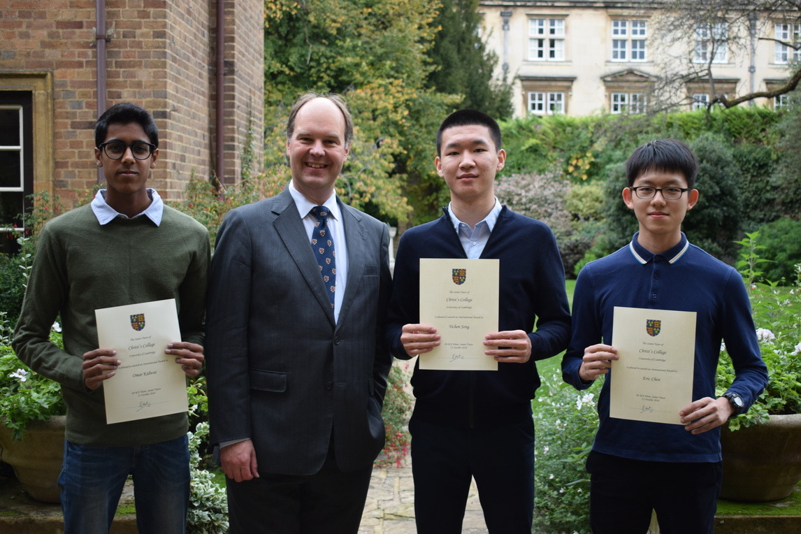 Dr Hunt and two students with their international award certificates
