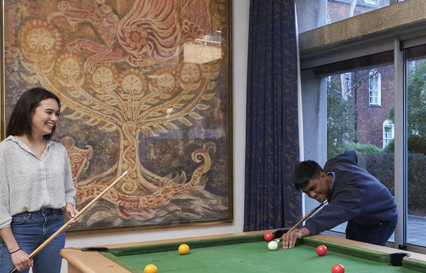 Students playing pool in the common room
